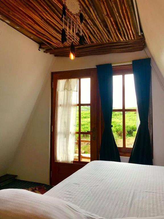 Bedroom with a tall window framing the green Boralanda hills